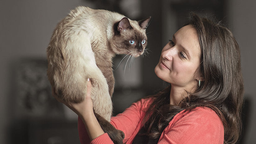 Frau hält Katze hoch