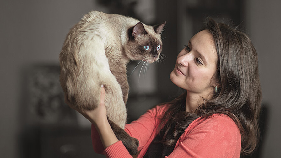 Woman holding her cat up