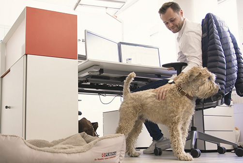 2.	PURINA Mitarbeiter streichelt seinen Hund auf der Arbeit dank Pets at Work